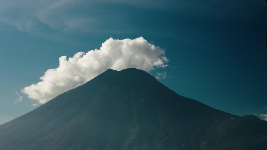 Clouds drift above San Pedro Volcano rising over Lake Atitlan waters