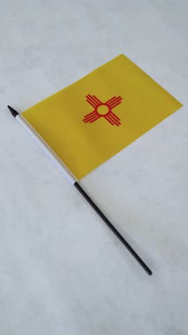 Vertical shot of New Mexico state flag on white background.