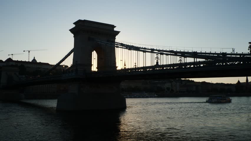 Silhouette of the Chain Bridge with a river cruise ship in the background, Budapest, Hungary