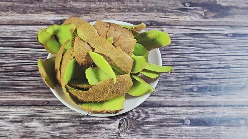 The remnants, waste and seeds of kiwi after being consumed, Kiwifruit kiwi, an edible berry from woody vines, known for its fuzzy brown skin, bright green flesh, tiny black seeds