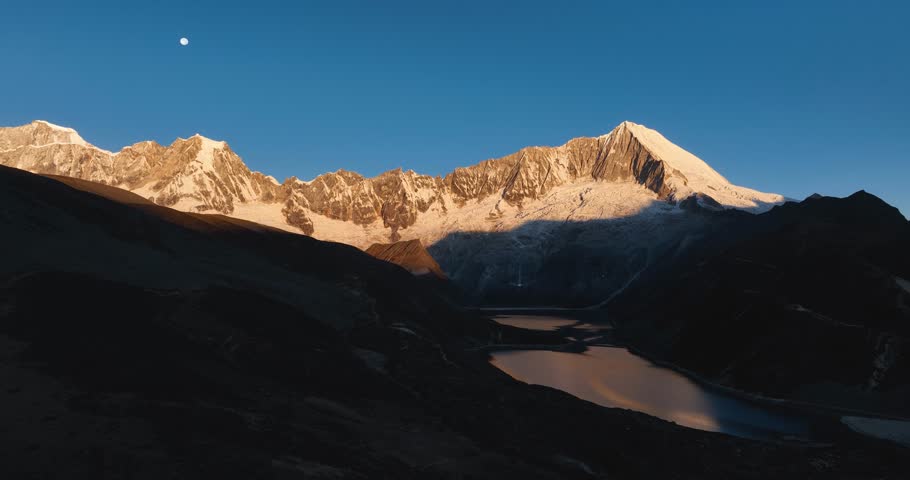 Aerial footage of beautiful snow capped mountain and lake sunrise landscape in Tibet, China