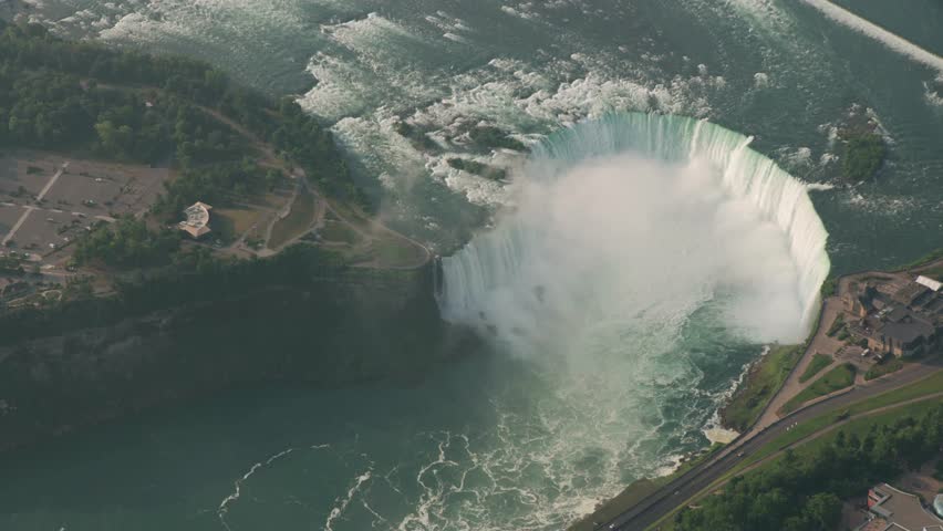 Witness Horseshoe Falls at Niagara Falls, Ontario, Canada, with an aerial view during daytime. The powerful cascade creates mist at the bottom of the waterfall.