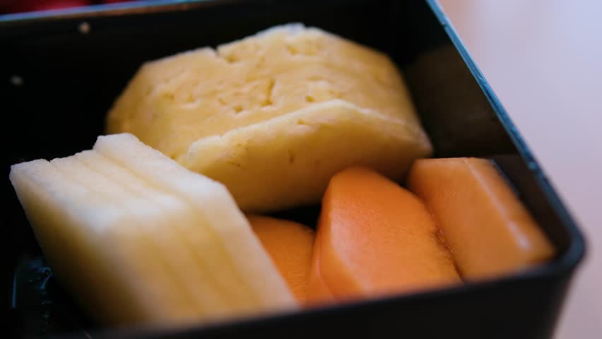 plastic container with fruits: watermelon, pineapple, papaya, melon