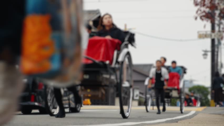 Traditional japanese rickshaw tour passing through a street in japan