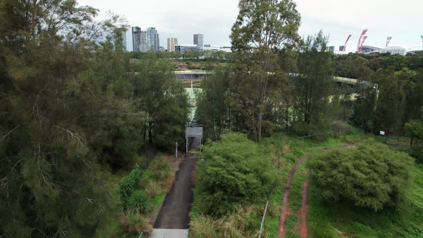 Aerial shot revealing the brickpit ring walk and water storage withe the engie stadium in the background on a cloudy day in Sydney Olympic Park, Sydney, New South Wales, Australia