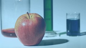 This video shows a syringe injecting a chemical into an apple in slow motion. The background is filled with colourful data, graphs, and statistics. The video ends with a digital generated pie diagram - Powered by Shutterstock - Get 15% off with code: PIKWIZARD15