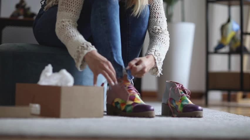 Female customer trying on shoes while shopping for footwear in shoe store. Young woman trying on modern shoes in shoe store. woman trying on shoes while shopping in shoe store.