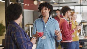 Office colleagues meeting in tech break area, holding mugs, showing animated social media icons. Collaboration, networking, workplace, communication, modern, informal, digital - Powered by Shutterstock - Get 15% off with code: PIKWIZARD15