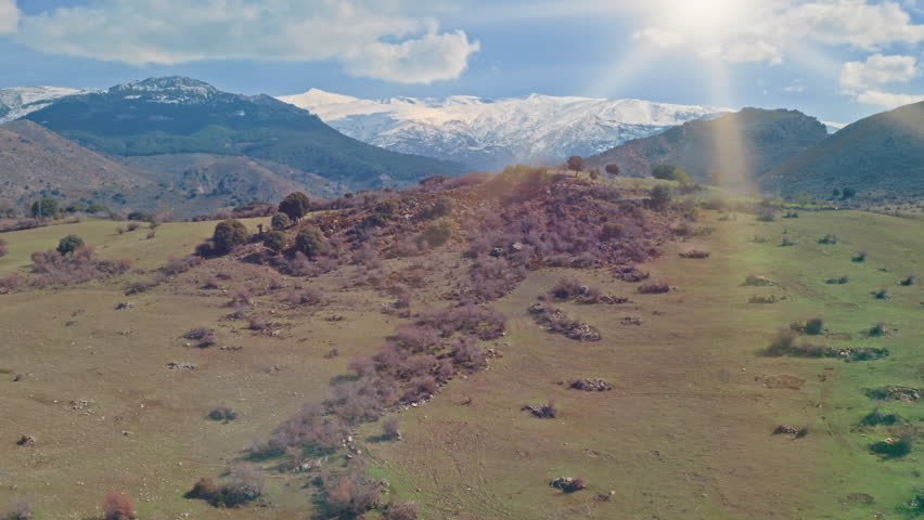 Drone flight from above Sierra Nevada valley park in Spain panorama tour hills vacation journey sun shining bright cloudy sky outdoors trip ground with rocks bushes plants adventure peak mountainous