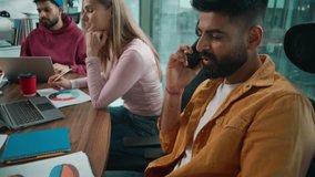 Diversity business team in office three multiracial colleagues informal Arabian businessman talking mobile phone Caucasian woman writing data Indian male thinking with laptop meeting working together - Powered by Shutterstock - Get 15% off with code: PIKWIZARD15