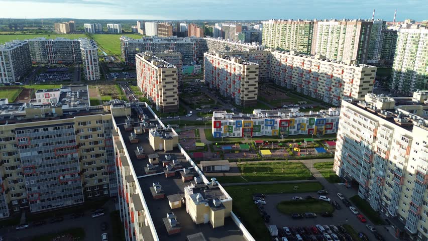 A cityscape with many tall buildings and a park in the middle. The buildings are mostly white and red