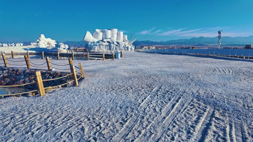 Chaka Salt Lake, Qinghai Province, China - A Wide Salt-covered Path Leads Toward Sculpted White Formations and Distant Mountains - Wide Shot