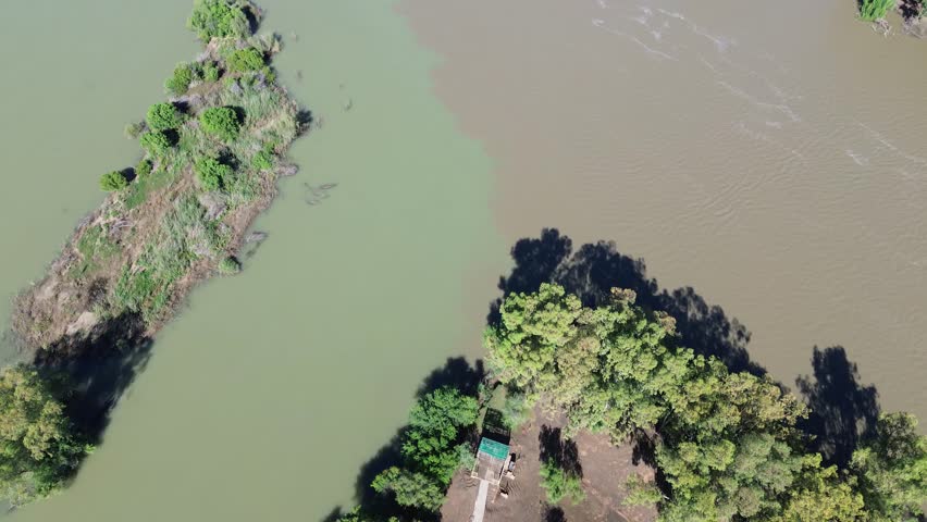 High POV Camera panning up along the Confluence of the Vaal River and the Orange River. South of the town of Douglas, Northern Cape, South Africa. 4K Aerial Video.