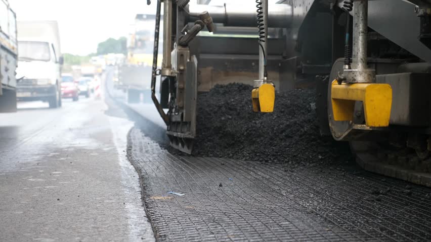 Special machinery making road in countryside area. Compactor constructing highway. Heavy machinery repairing road. Slowly driving roller laying new asphalt layer. Roadwork process. Roadway repair