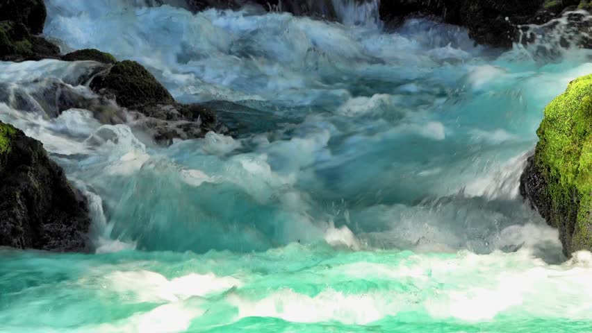 Peaceful lake and river landscape with calm water reflecting blue sky and clouds, surrounded by green forest trees and grass. Serene summer nature scene in a countryside park.