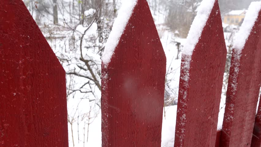 Stockholm, Sweden A red picket fence in a snowstorm. 