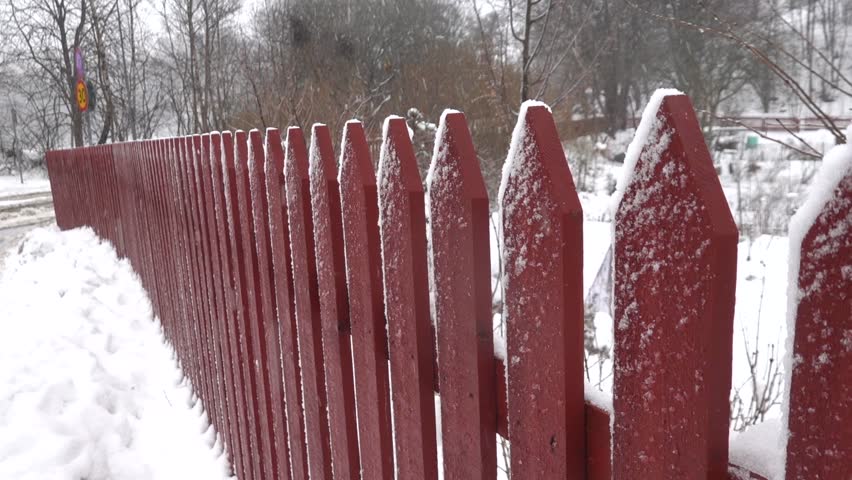 Stockholm, Sweden A red picket fence in a snowstorm. 