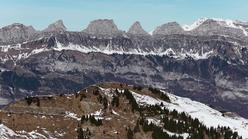 Aerial view of the Churfirsten mountain range above Walensee and Flumserberg in Switzerland, featuring dramatic alpine peaks such as Selun, Brisi, and Hinterrugg in winter scenery.