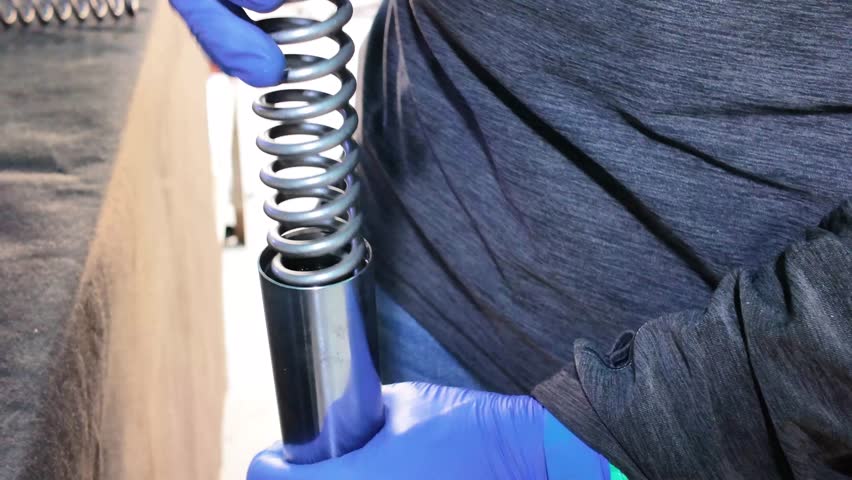 Mechanic Assembling Motorcycle Suspension Fork Parts Close-Up View