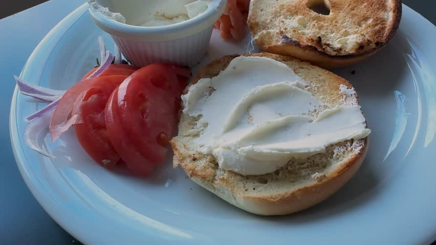 Addng Salmon Lox to a Bagel with Cream Cheese