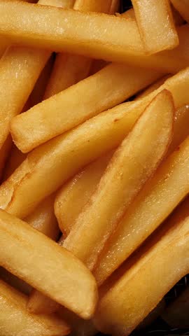 Cooking french fries potatoes in deep fryer. Closeup. Vertical footage