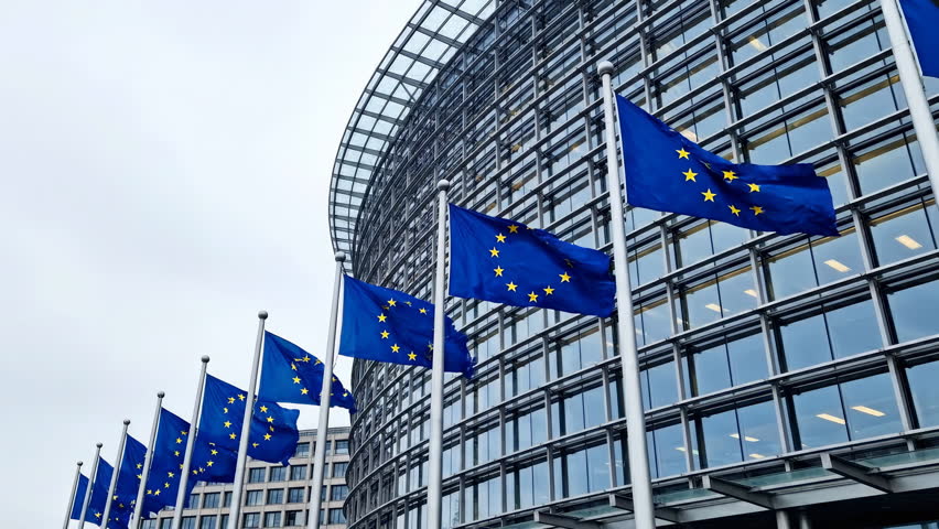European Union flags waving at the Parliament building in Brussels