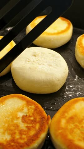 Cooking cheesecakes on frying pan. Closeup. Vertical footage