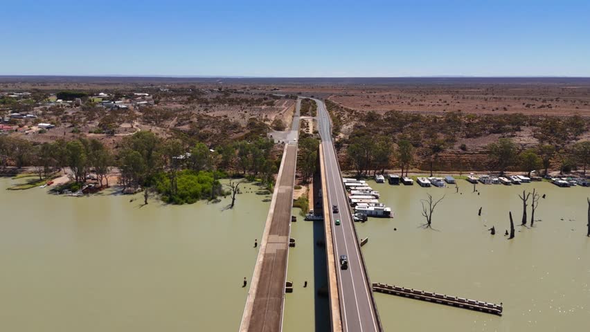 Overhead drone tracking straight bridge across vast river and surrounding flats, Blanchetown Adelaide Australia