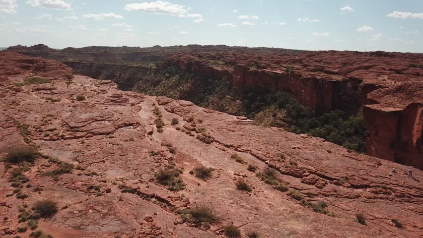 Drone footage of Kings Canyon in Australia’s Northern Territory, revealing vast red rock cliffs and dramatic desert landscape from an aerial perspective.