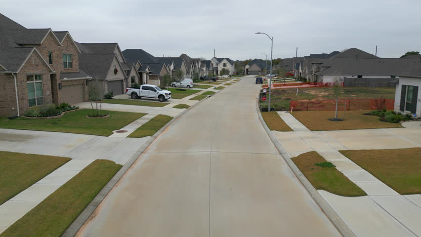 Suburban housing development with large open lawn lots and brand new roads