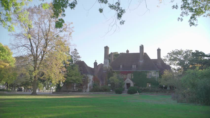 Historic stone buildings at Grosse Point Light Station surrounded by trees and lawn.