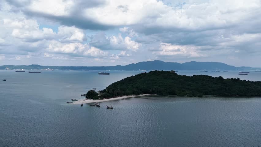Aerial view of a serene coastline with lush green island