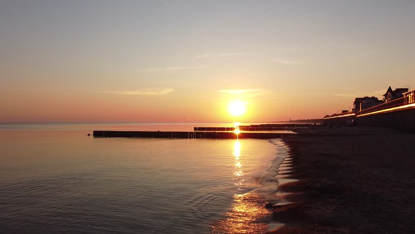 Evening Coast Scene, Serene Coastal View At Dusk, Sunset Illuminating Tranquil Bay And Distant Promenade Silhouette, Dusk Over Seaside Jetties With Gentle Reflections And Quiet Urban Horizon