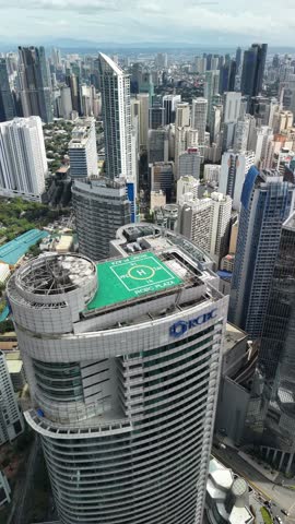 Stunning vertical aerial footage capturing a full 360-degree panoramic rotation high above the Makati Central Business District in Metro Manila, Philippines. This dynamic revolving shot showcases the impressive concentration of contemporary high-rise buildings, corporate headquarters, and residential condominiums that define one of Southeast Asia