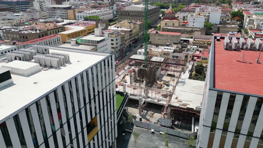 Aerial cityscape of Guadalajara, Mexico. Modern striped buildings and traditional architecture blend, creating a vibrant urban creative digital hub