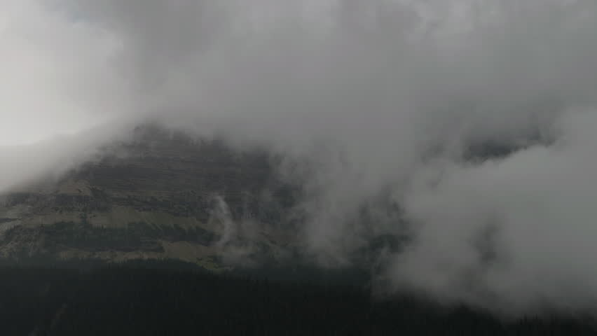 Misty Montana mountain in clouds, evokes mystery and tranquility