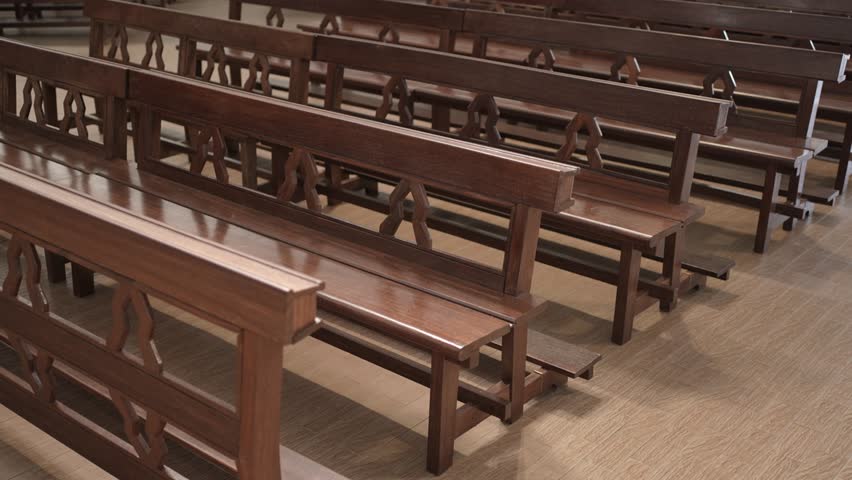 Empty wooden pews aligned inside a quiet church interior