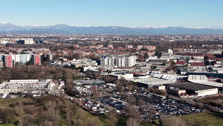 Stunning panoramic view of the city of turin, italy, showing the urban landscape and industrial areas with the majestic alps on the horizon