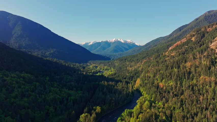 Aerial drone view of Olympic National Park in Washington, showcasing rugged mountain landscapes, forested slopes, and scenic alpine terrain. Ideal for nature and travel footage