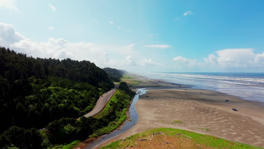Aerial drone view of Seabrook, Washington, showing beach, Pacific Ocean waves, and coastal shoreline. Dynamic seaside scenery ideal for travel, nature, and ocean footage.