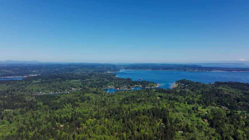 Aerial drone view of Olympic National Park, Seattle, Washington, showcasing a pristine mountain lake surrounded by forest and alpine peaks. Serene, natural landscape.