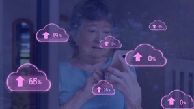 Animation of clouds with uploading over senior caucasian woman using smartphone. Cloud computing, communication and technology concept digitally generated video. - Powered by Shutterstock - Get 15% off with code: PIKWIZARD15
