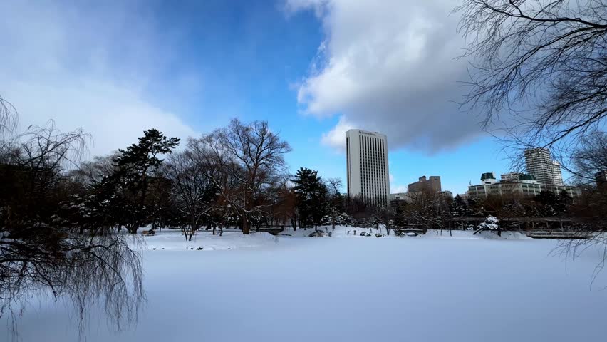 Winter view of Nakajima Park in Sapporo, peaceful snowy scene with buildings