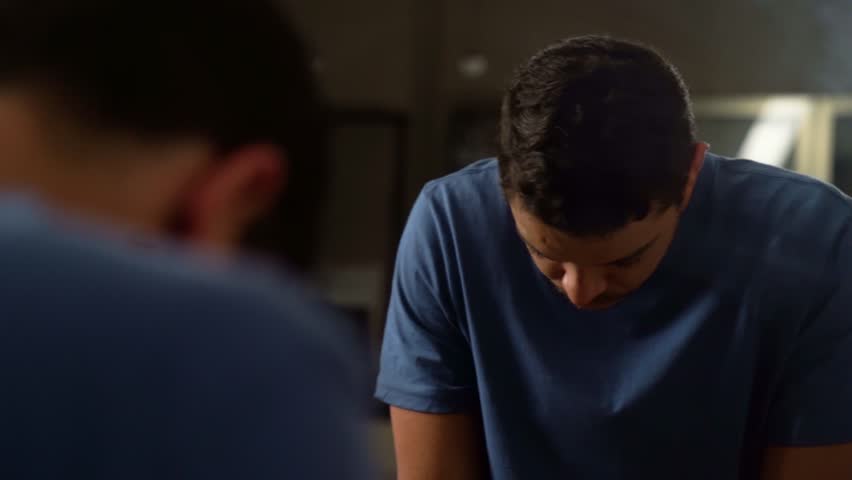 Serious man Staring at Himself in the Mirror at Night
