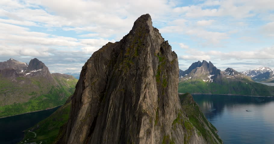 Drone flyover rocky mountain peak of Segla, fjords and mountain ranges background. Norway.