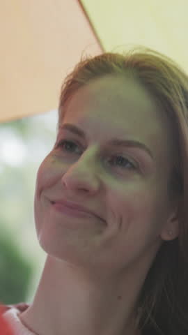 Woman talking to a man under a colorful umbrella