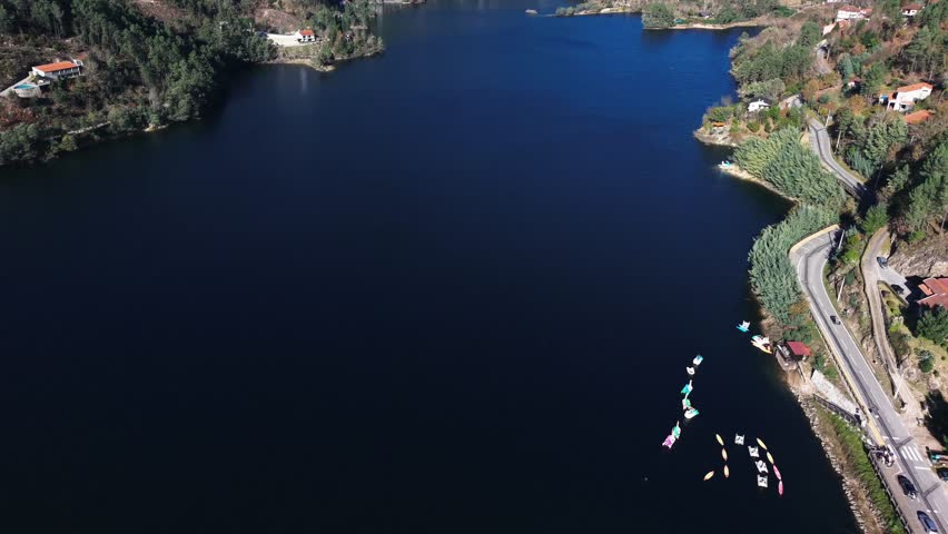 Drone view of Canicada reservoir shoreline with boats in Terras de Bouro