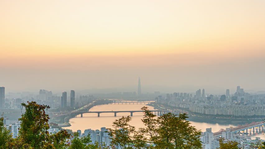4K time-lapse video (Zoom Out) of a sunrise from Mount Maebongsan in autumn, central Seoul, the Han River, and the Lotte Tower in Seoul, South Korea.