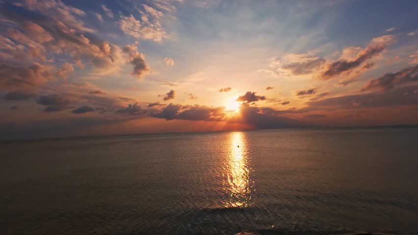 Aerial Sunset Above Palm Tree Forest And Calm Sea With Sun Rays Breaking Through Clouds, Dramatic Tropical Evening Landscape.