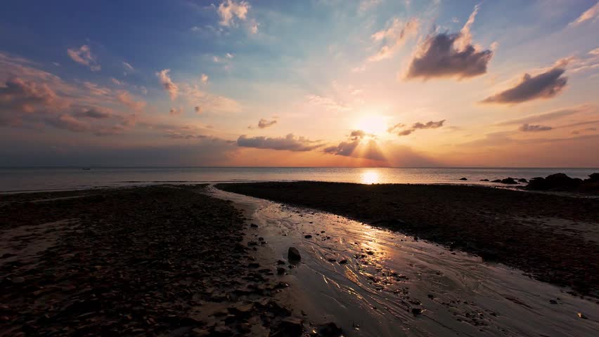 Wide Aerial View of Rocky Tropical Shoreline at Sunset With Calm Ocean And Dramatic Clouds, Golden Sunlight Creating Peaceful Travel Mood And Natural Freedom.
